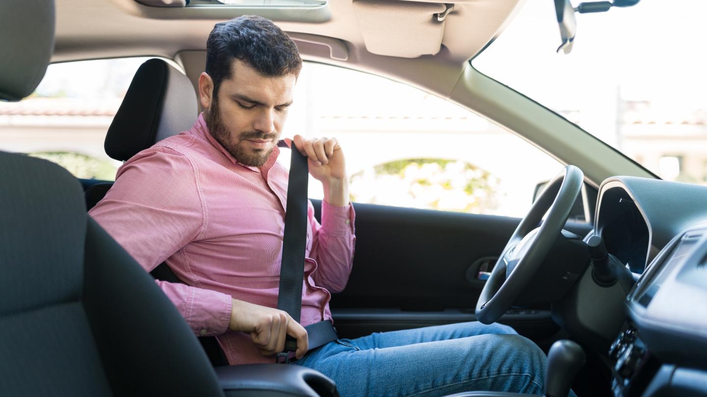 man buckles seat belt